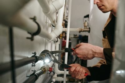 Technician inspecting commercial plumbing pipes in Santa Clara