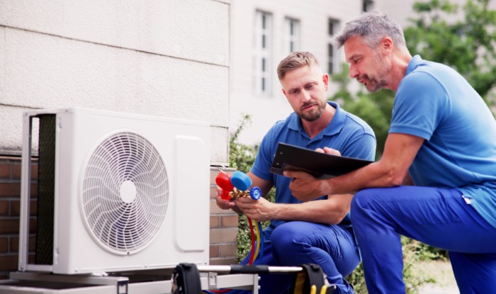 HVAC technicians installing an outdoor air conditioning unit in Santa Clara