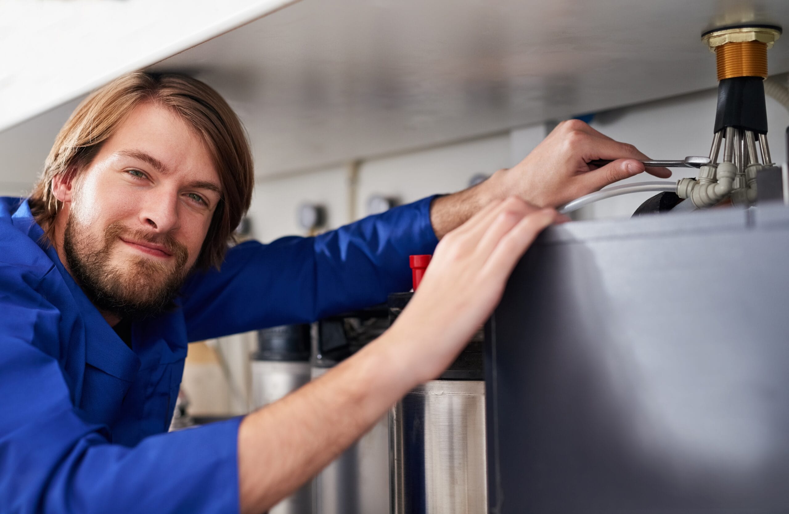 Technician servicing a residential water heater tank in Santa Clara